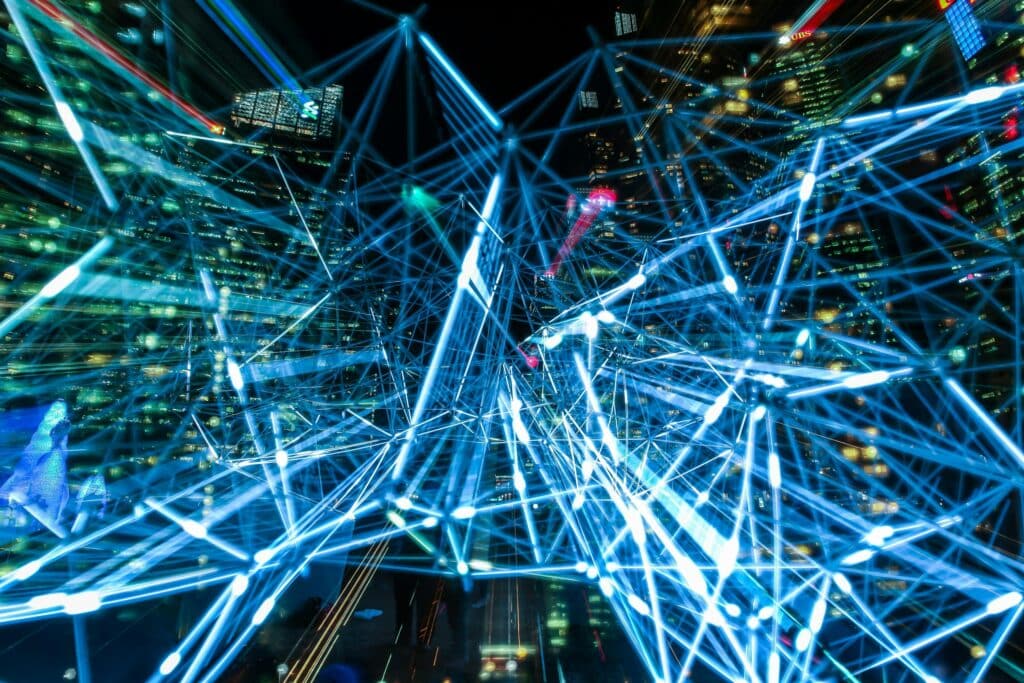 Glowing blue lines forming a network over a night city skyline